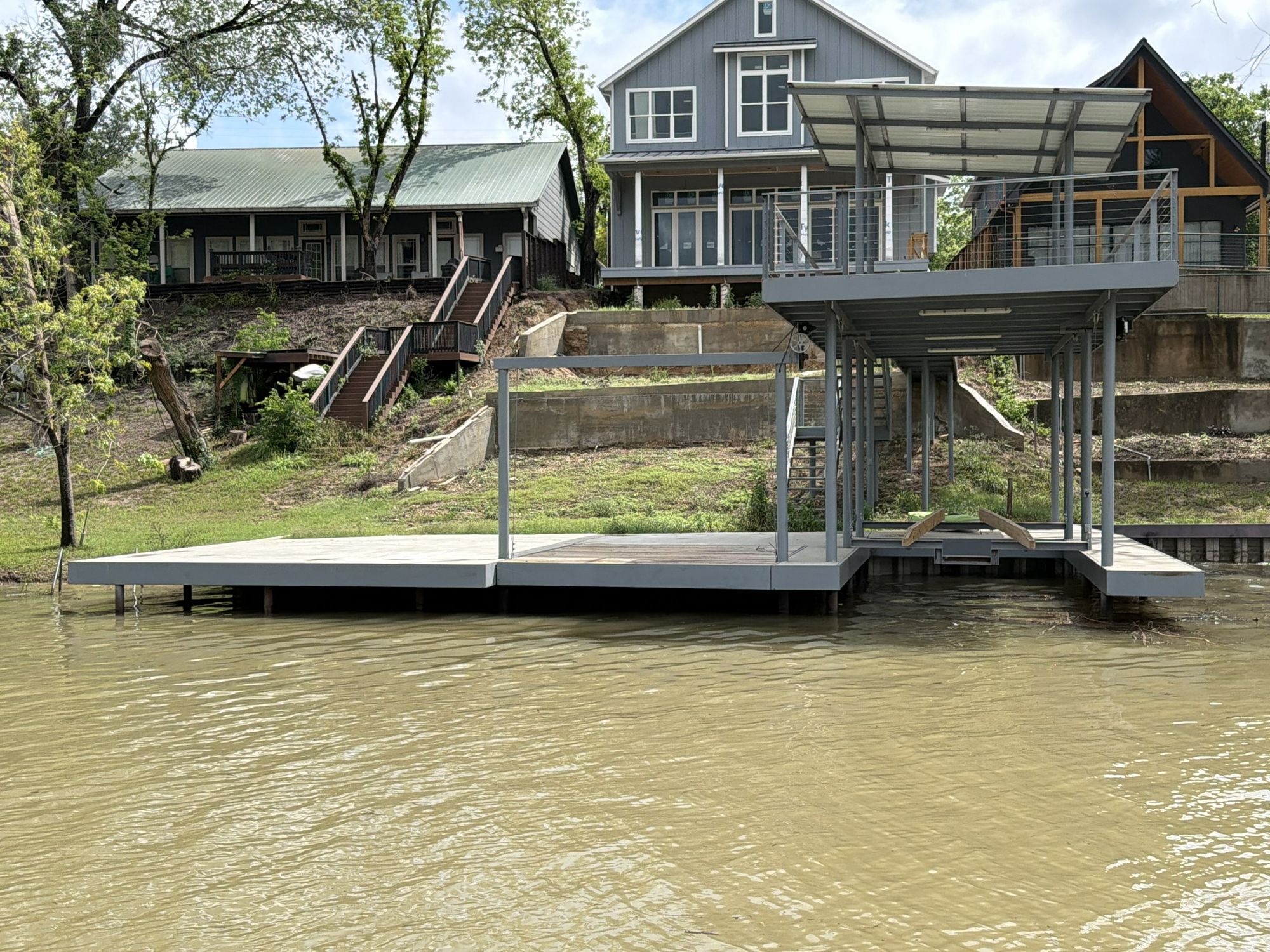 Boathouse with covered upper patio and jet ski pivot on Lake Placid by Waterfront Unlimited