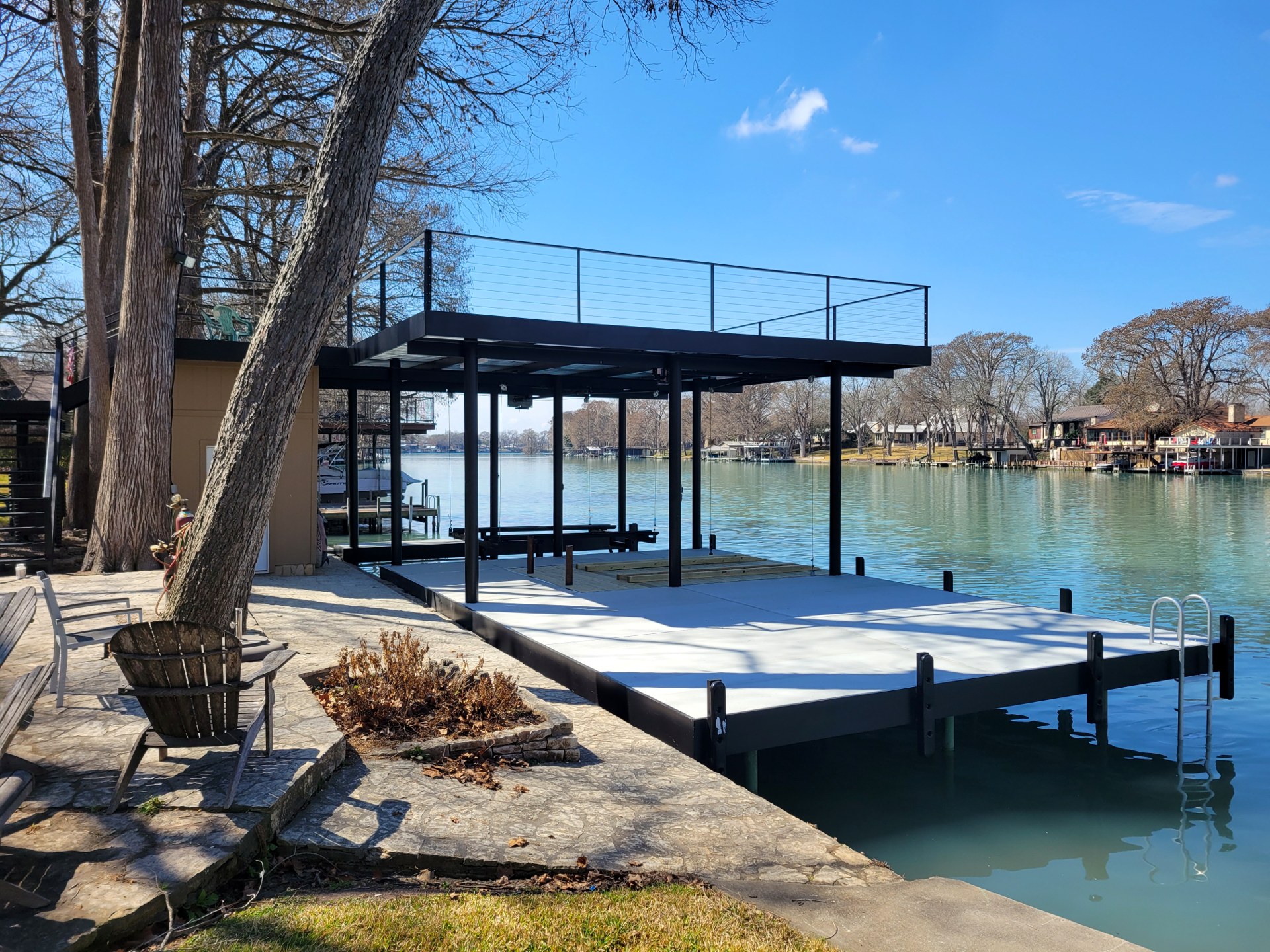 Steel boathouse with upper-level deck and dock on Lake McQueeney built by Waterfront Unlimited