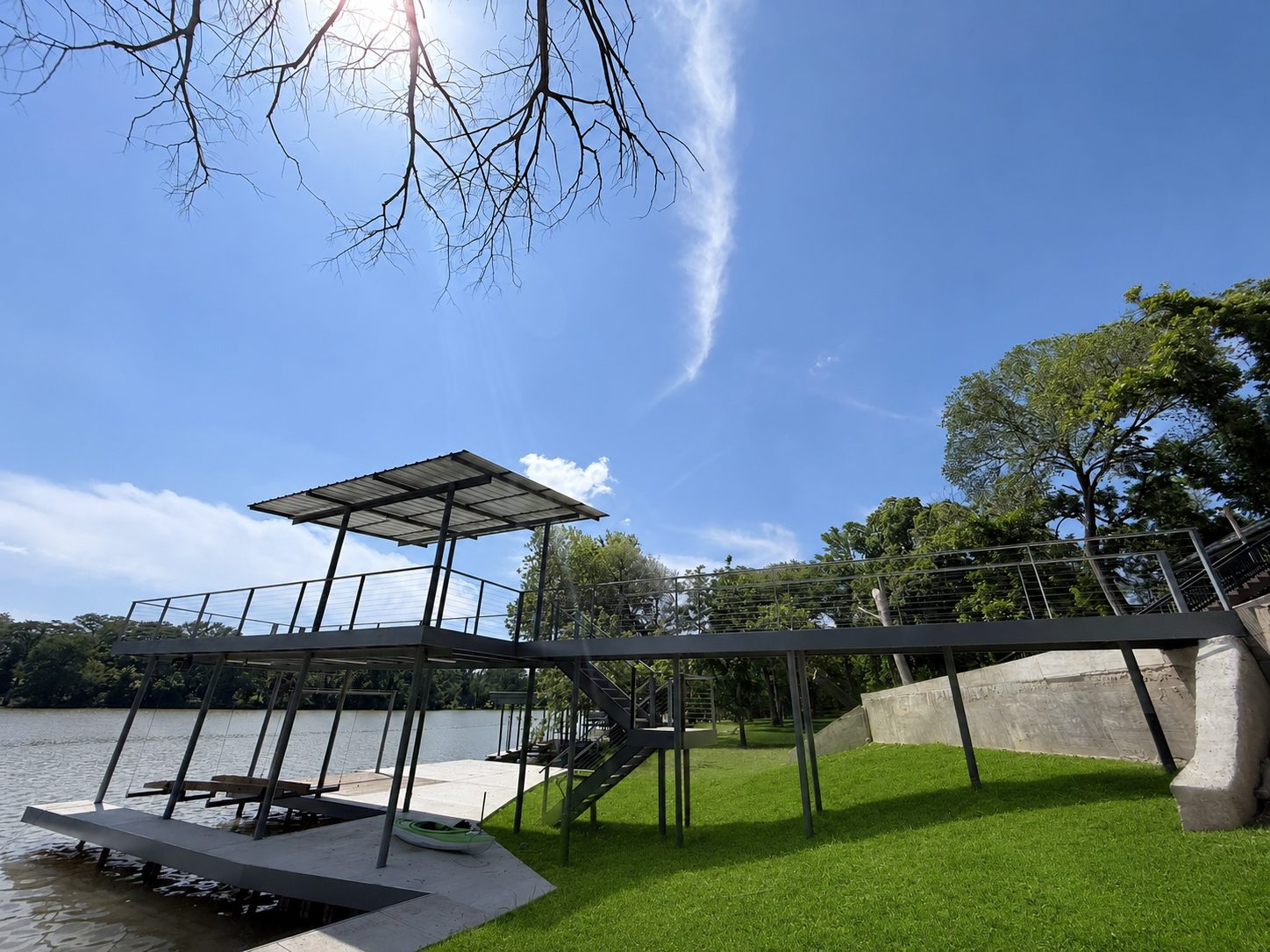 Boathouse with roofed upper patio, bulkhead, and dock on Lake Placid by Waterfront Unlimited