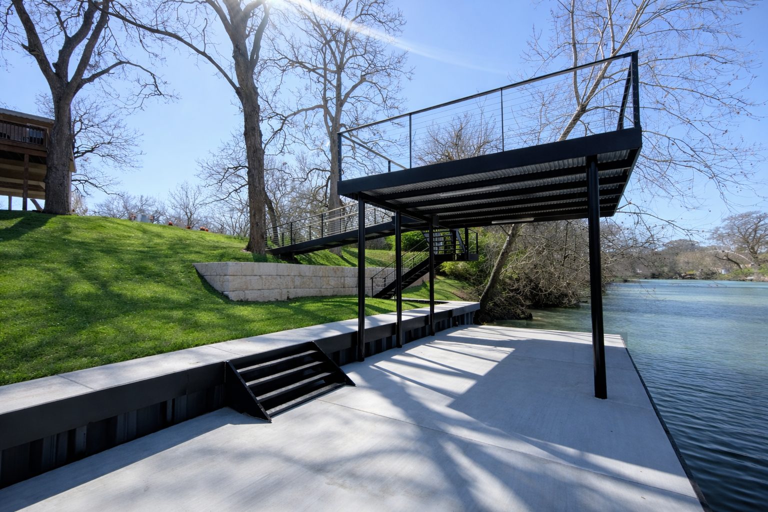 CLOC vinyl bulkhead, concrete dock, upper patio, and custom steel ramp on Lake Seguin by Waterfront Unlimited