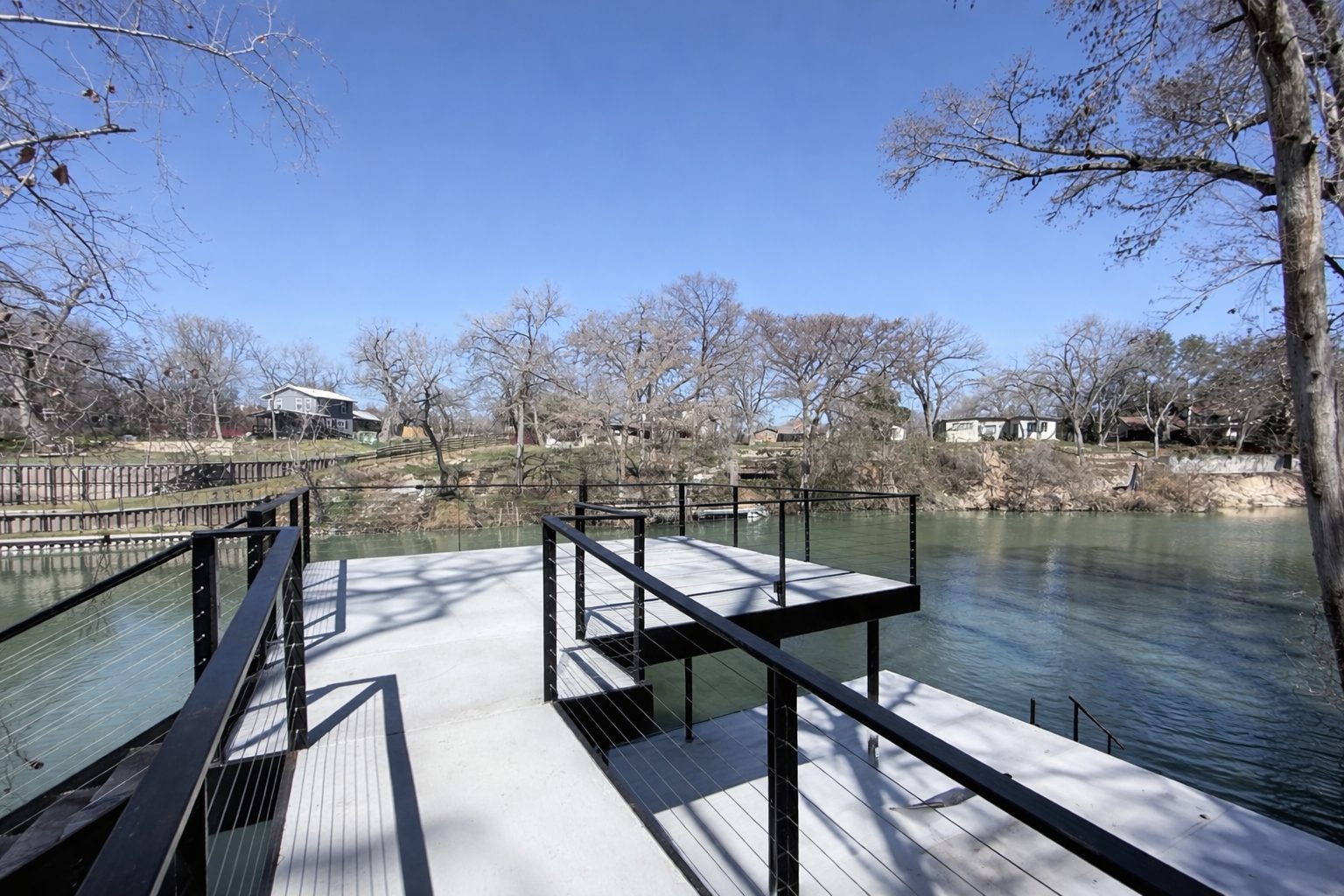 Concrete dock with upper-level patio and 9-strand cable rails on Lake Seguin by Waterfront Unlimited